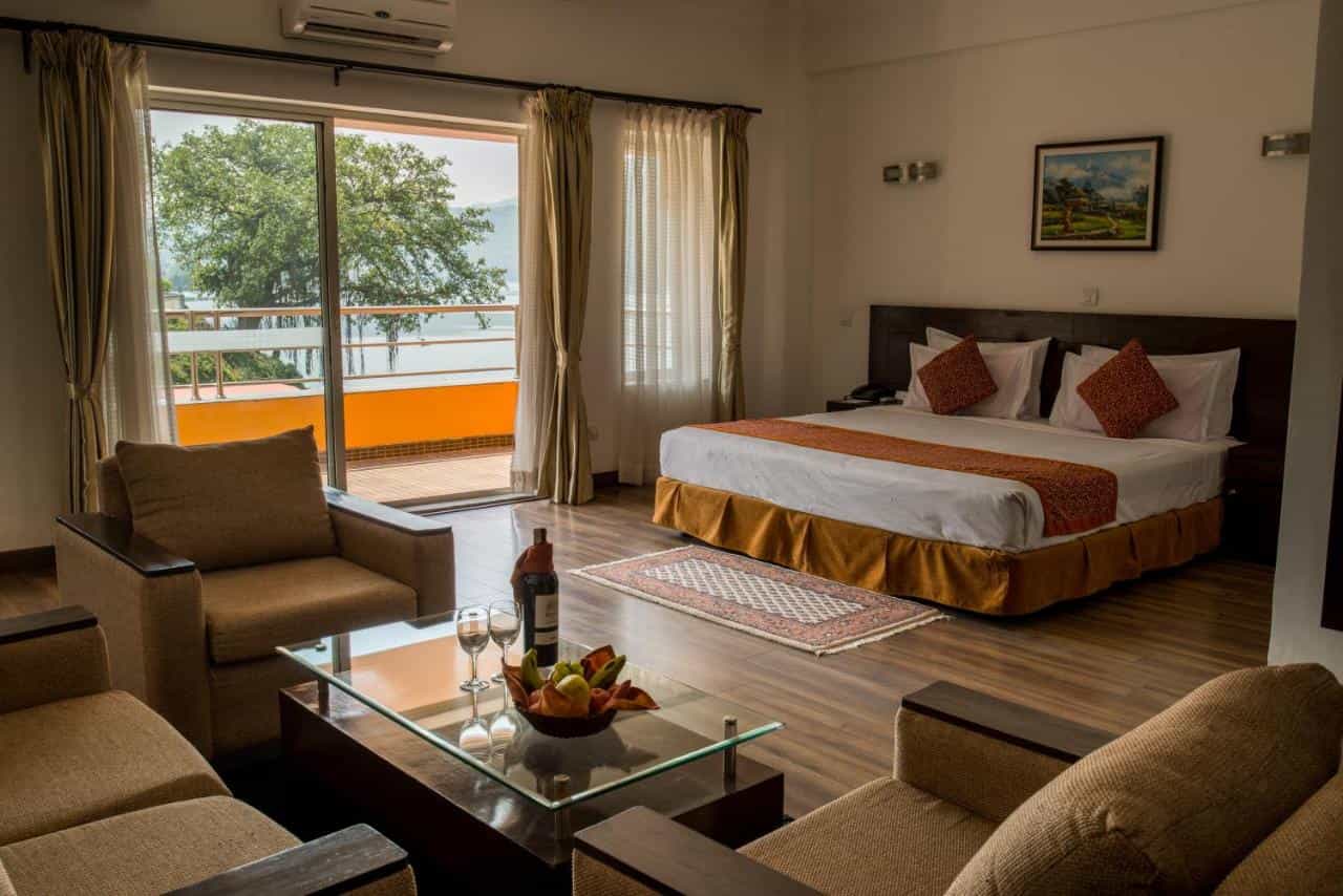Waterfront resort room in Pokhara with lake view balcony and seating area