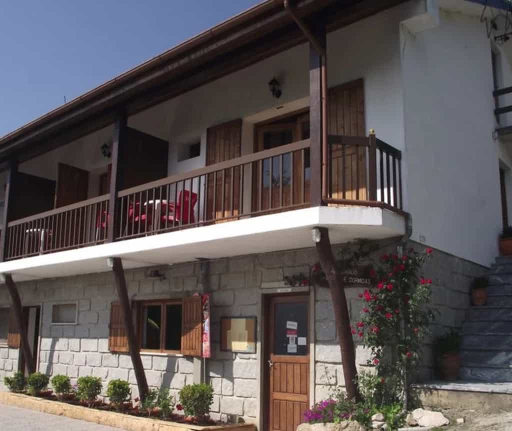 Stone and white building with wooden balconies, Casa do Criado in Geres outside.
