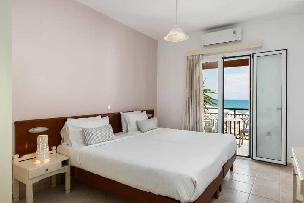 Hotel room with double bed, balcony access, and view of the blue sea