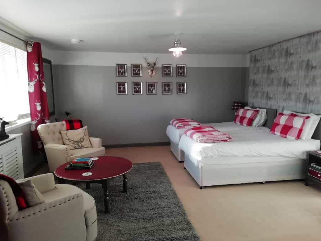 Guest house bedroom with twin beds, seating area, and deer-themed decor