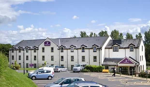 Premier Inn Glasgow (Milngavie) hotel exterior with parking lot and blue sky