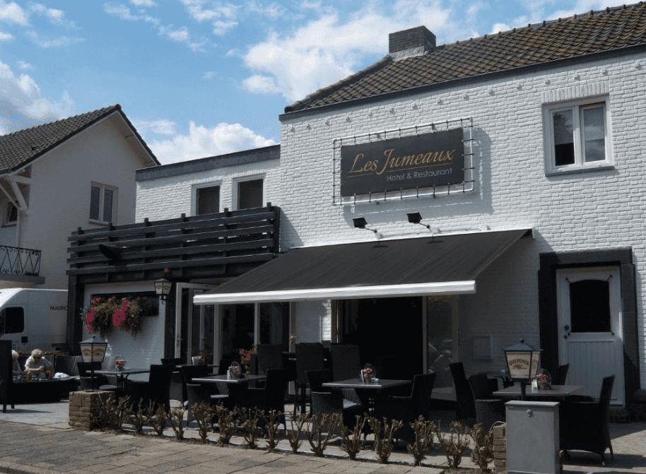 Les Jumeaux Hotel & Restaurant with outdoor patio seating under a black awning