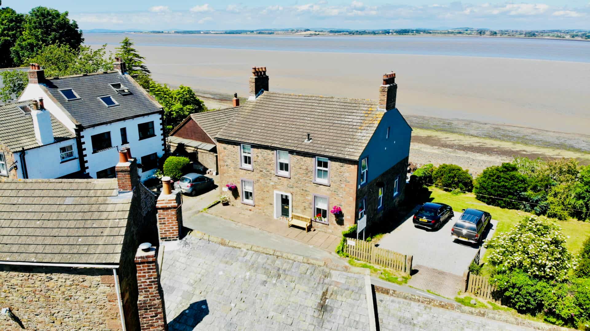 Stone Shore Gate House Bed & Breakfast overlooking wide tidal estuary on sunny day.