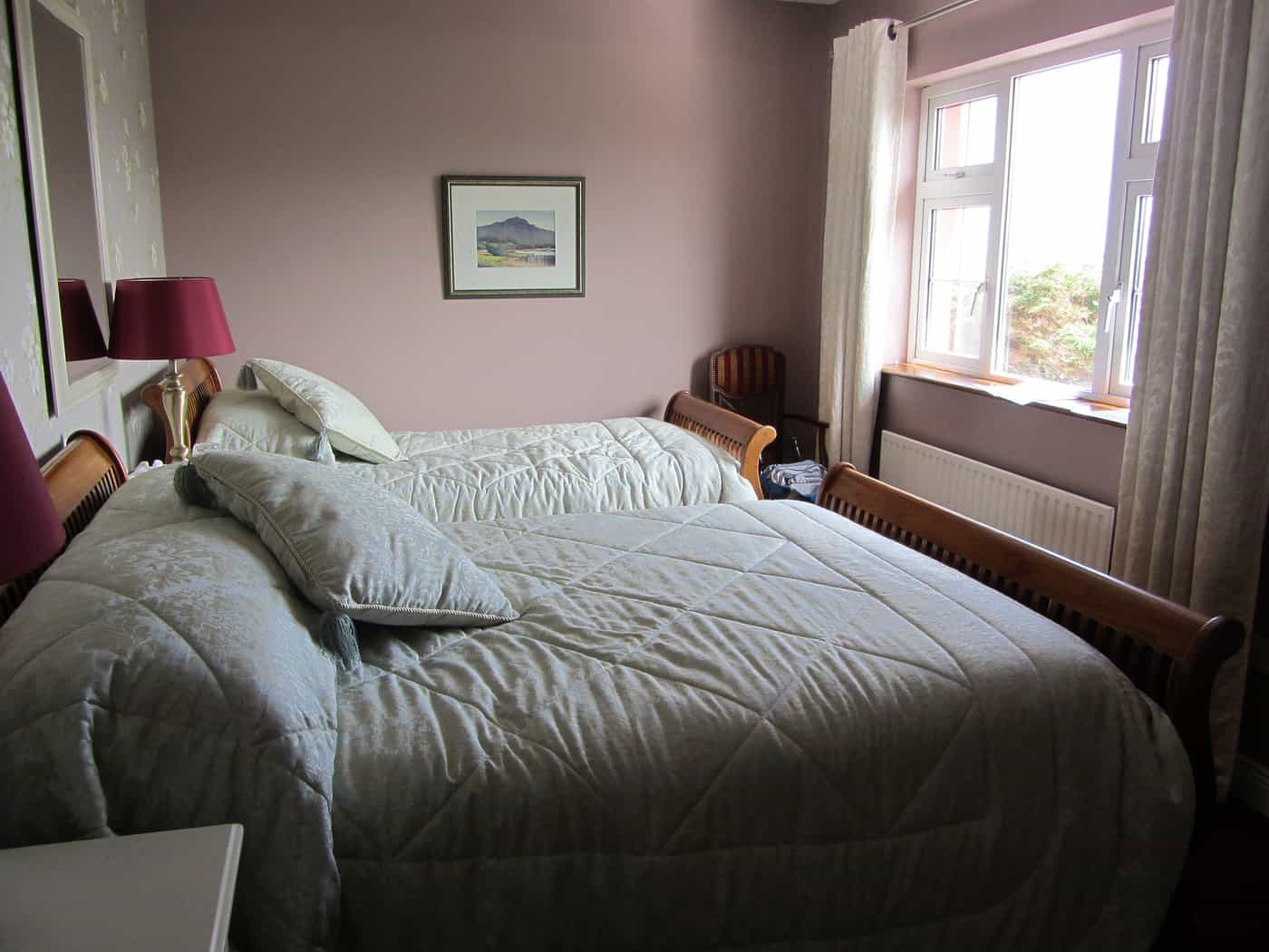 Twin beds with quilted light blue bedding in a Castle House Bed and Breakfast room.