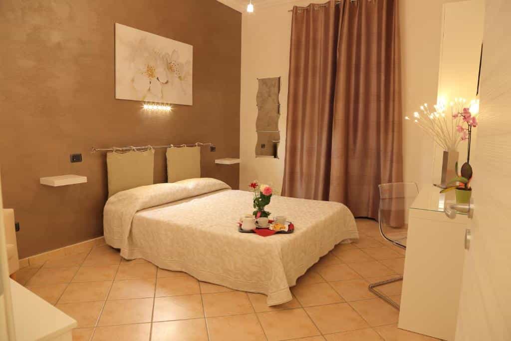 Bedroom with large bed, tray service, and brown textured walls, likely La Terrazza sulla Valle.