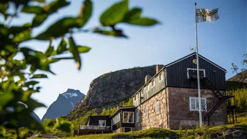Kebnekaise mountain hut with flag in Swedish alpine landscape.