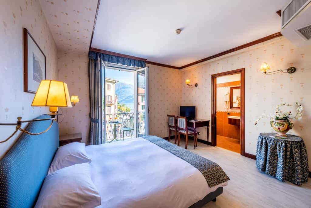 Hotel room with bed and balcony view of Lake Menaggio mountains and water