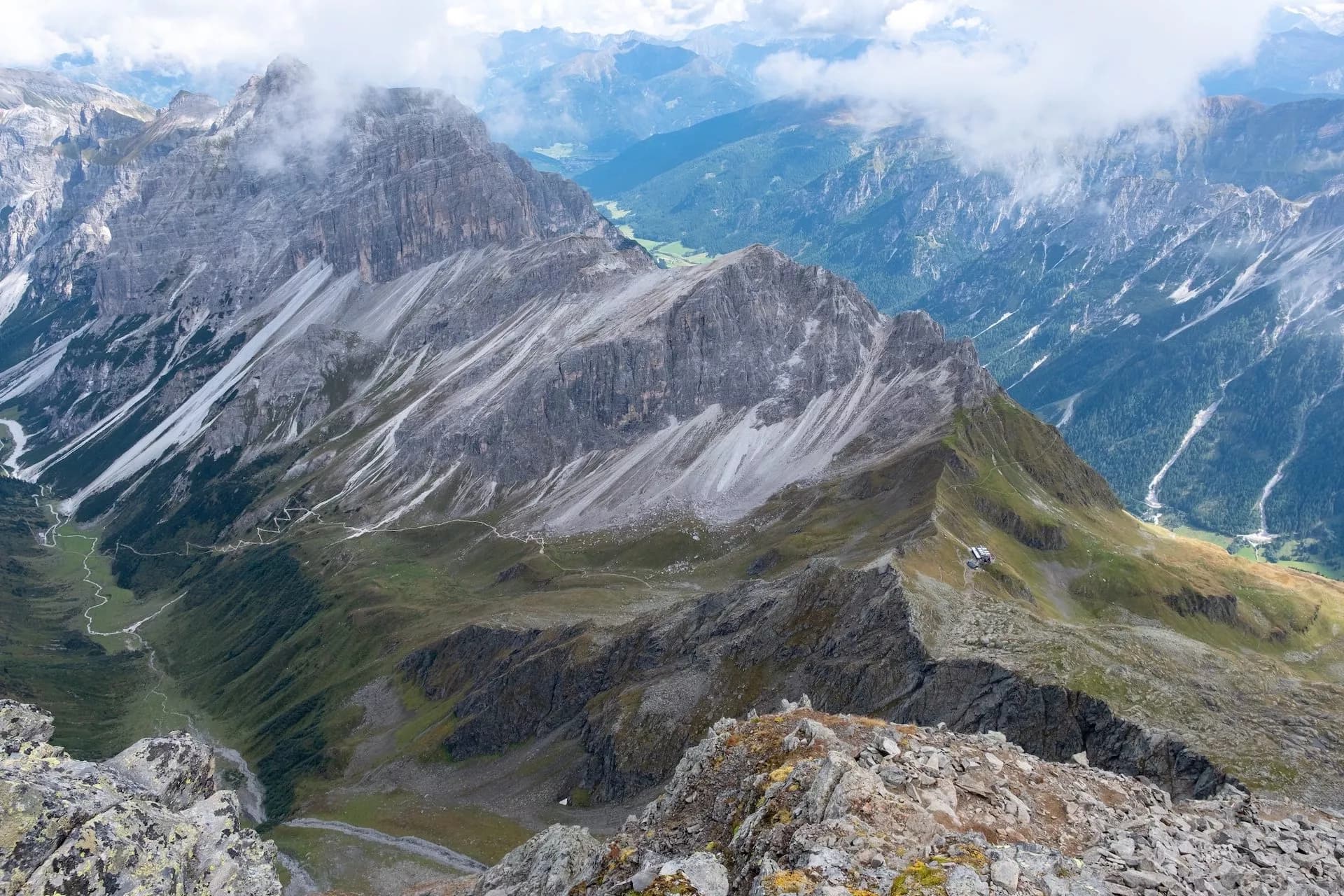 Rocky alpine peaks with the Innsbrucker Hutte visible above a steep valley.