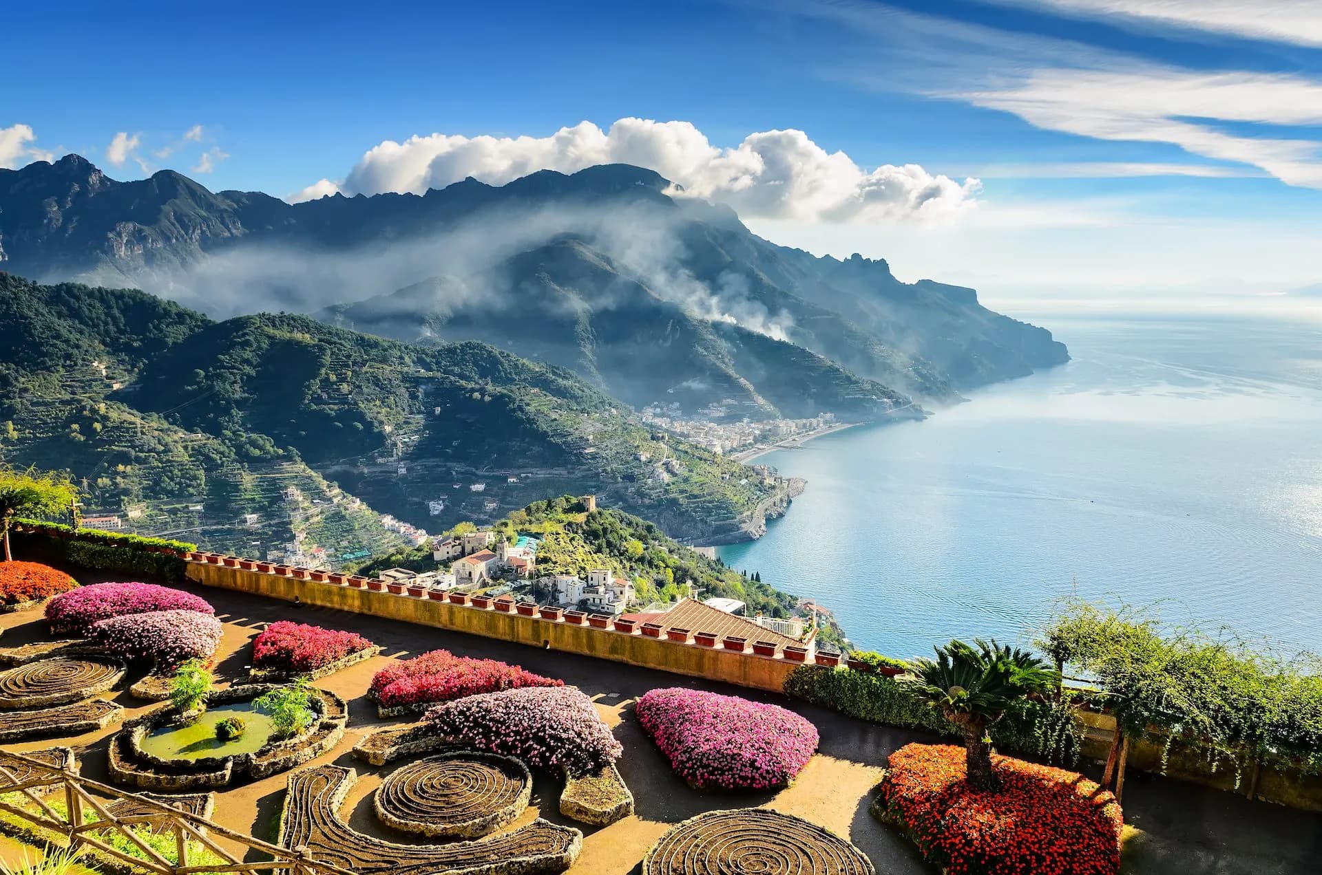Terraced gardens with colorful flowers overlooking the sea and mountains of Ravello.