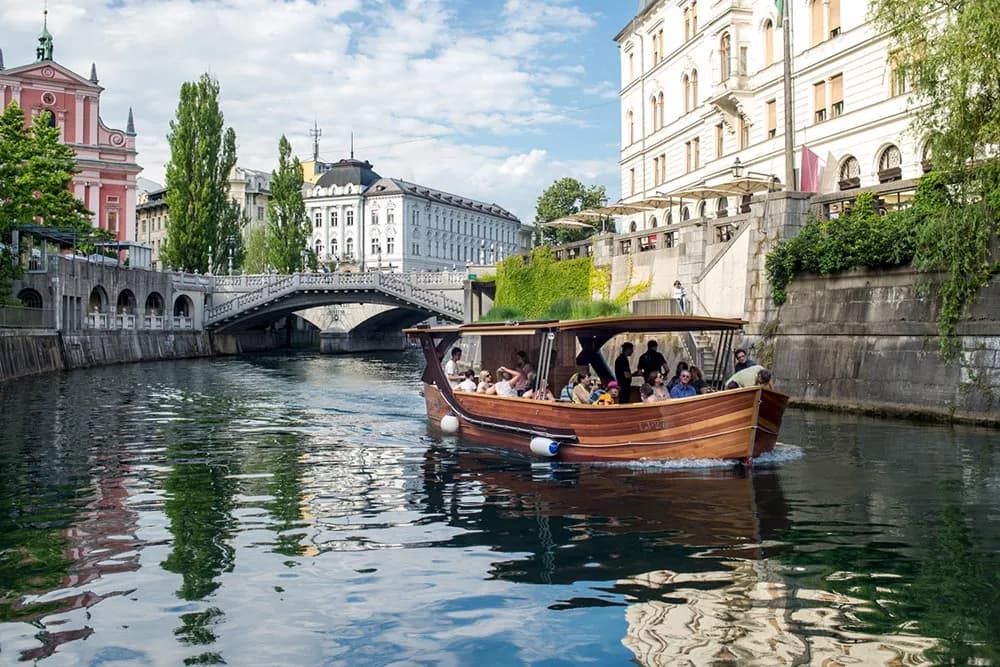 Wooden tour boat with passengers on the Ljubljanica River in Ljubljana, Slovenia.