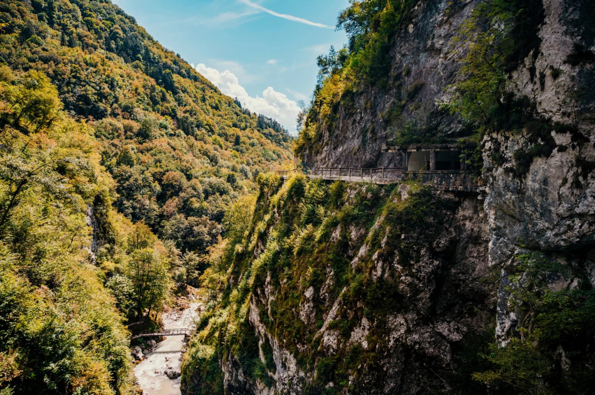 Pathway carved into steep cliffside above river in Tolmin Gorge, Slovenia.