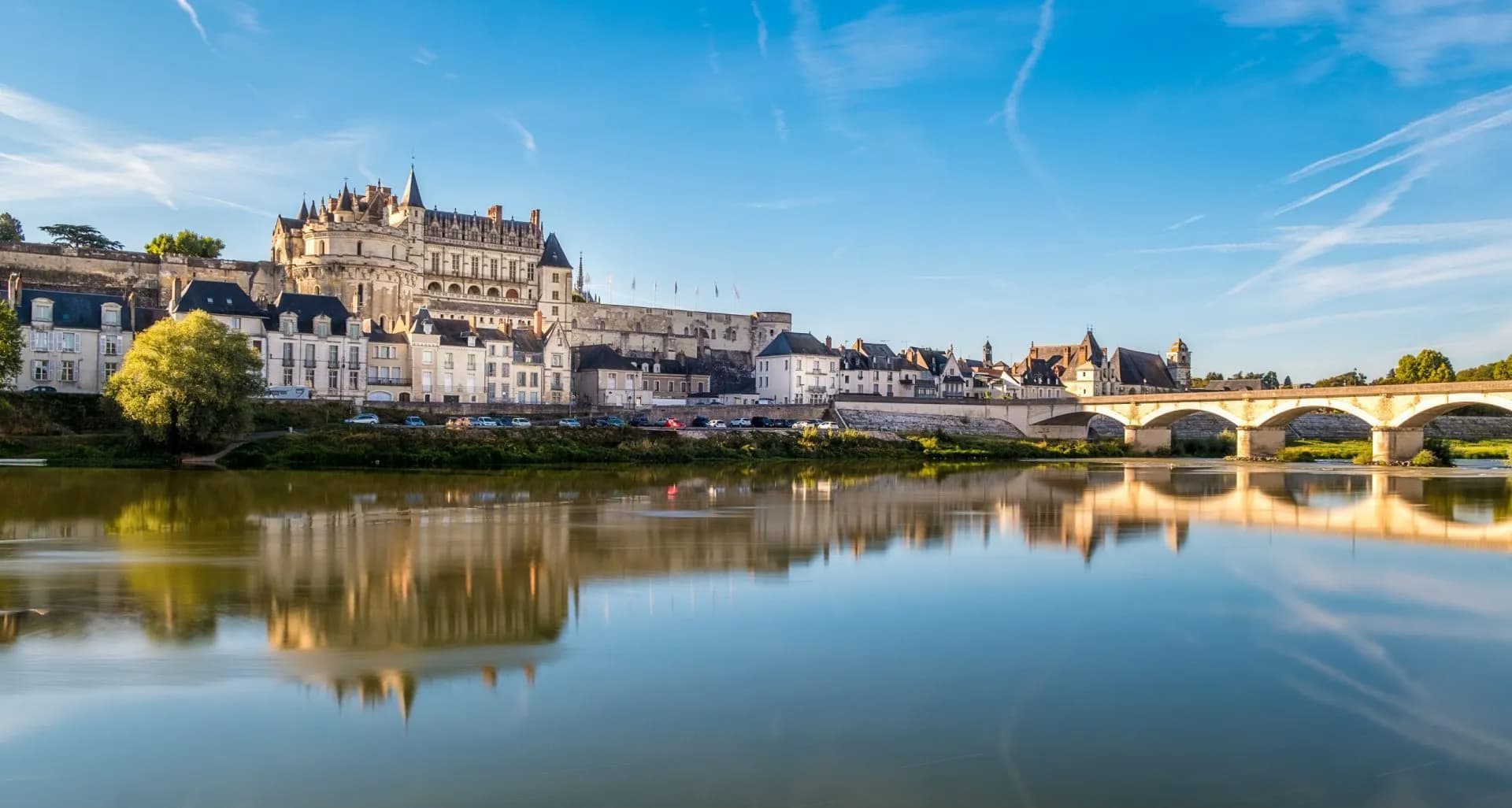 Chateau d'Amboise overlooking the Loire River with stone bridge reflection
