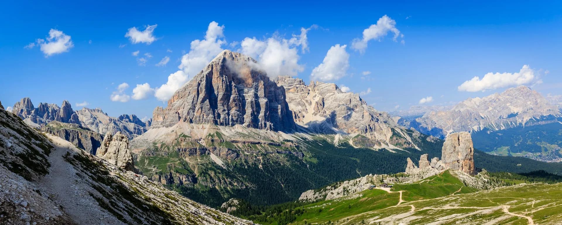 Tofana di Rozes mountain peaks in the Dolomites under a blue sky with white clouds, summer hiking.