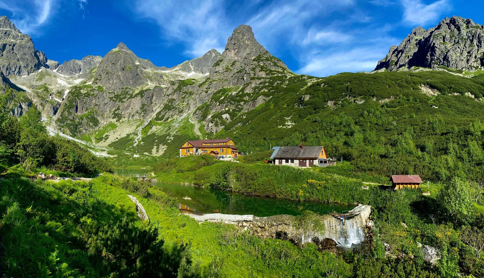 Slovakia landscape. Hut near the Zelene pleso, Vysoke Tatry NP, Europe. Sunny say in the mountains. Rocky hill isn summer season. High Tatras, lake with green forest. Travel in Slovakia.
