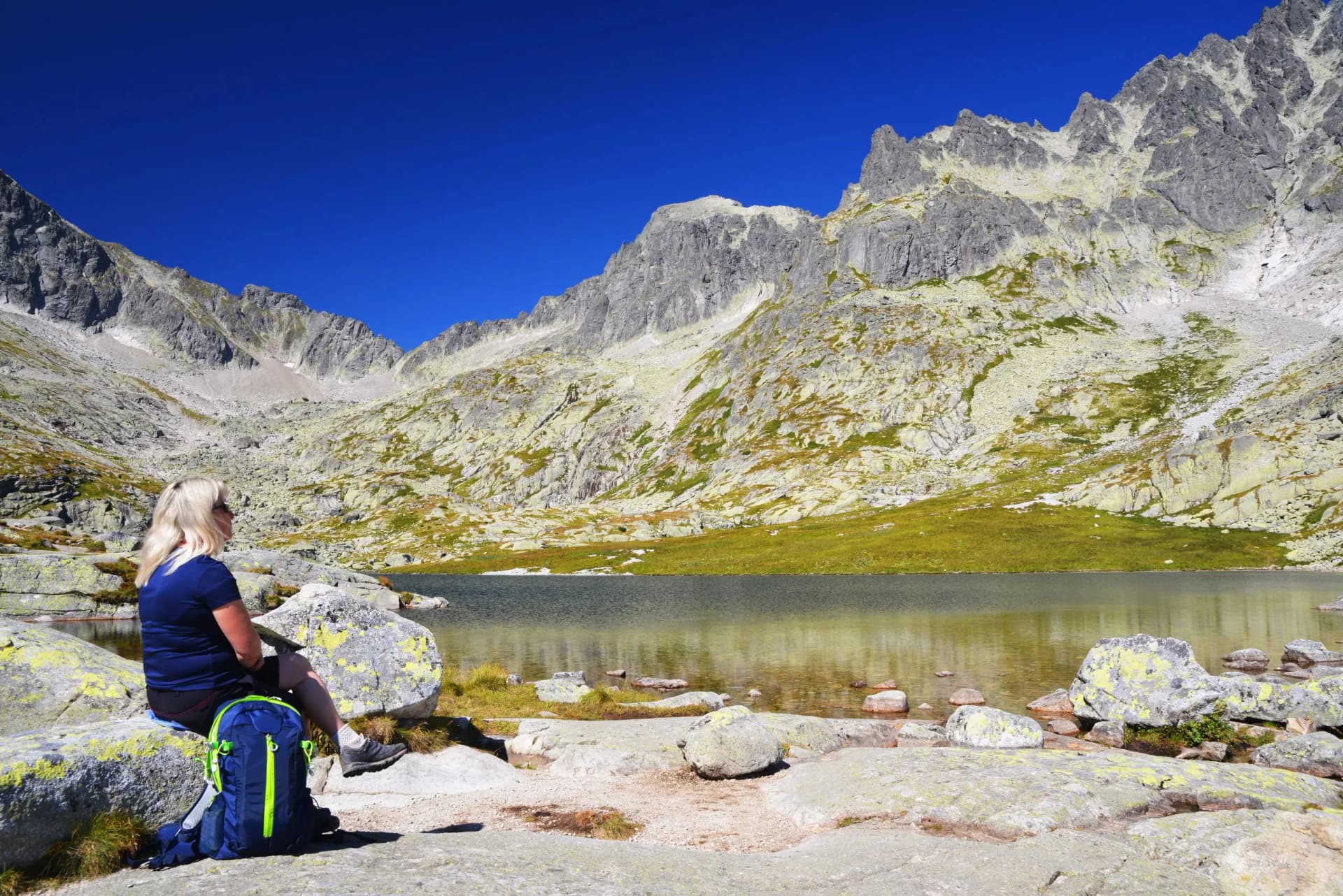 Tourist at the lake Prostredne Spisske pleso in Mala Studena Dolina, Vysoke Tatry (Tatra Mountains), Slovakia.