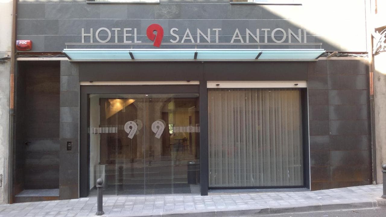 Hotel 9 Sant Antoni entrance with dark stone facade and glass automatic doors