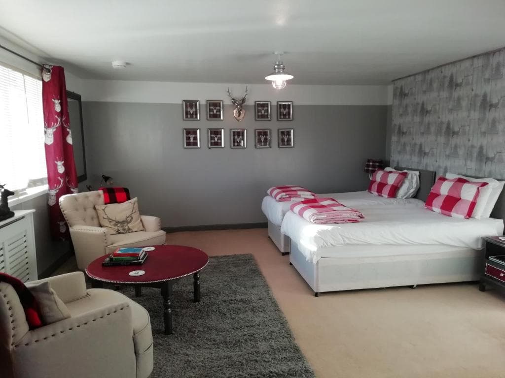 Guest house bedroom with twin beds, seating area, and deer-themed decor
