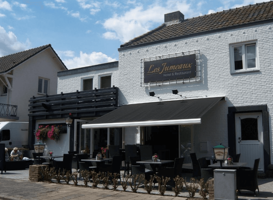 Les Jumeaux Hotel & Restaurant with outdoor patio seating under a black awning