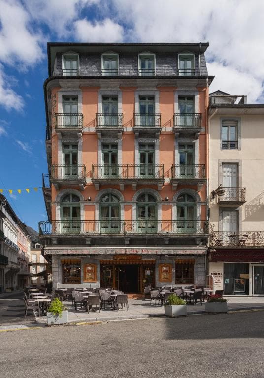 Hotel Le Bois Joli cafe with outdoor seating on street under blue sky