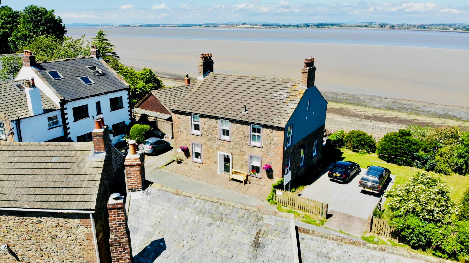 Stone Shore Gate House Bed & Breakfast overlooking wide tidal estuary on sunny day.