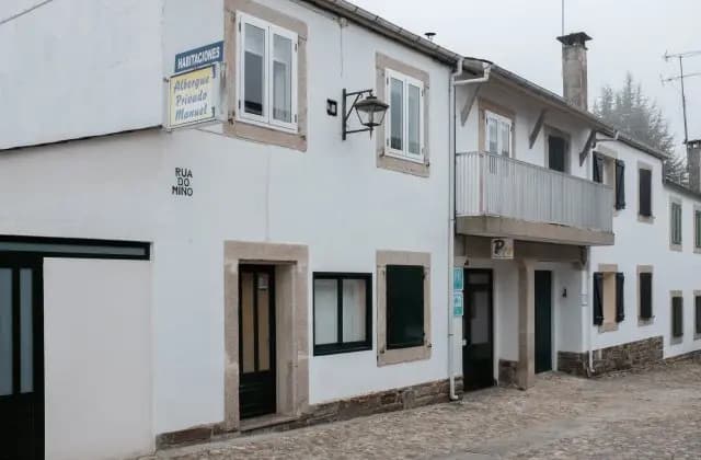 Albergue Privado Manuel accommodation on Rua do Mino with white facade and cobblestone street.