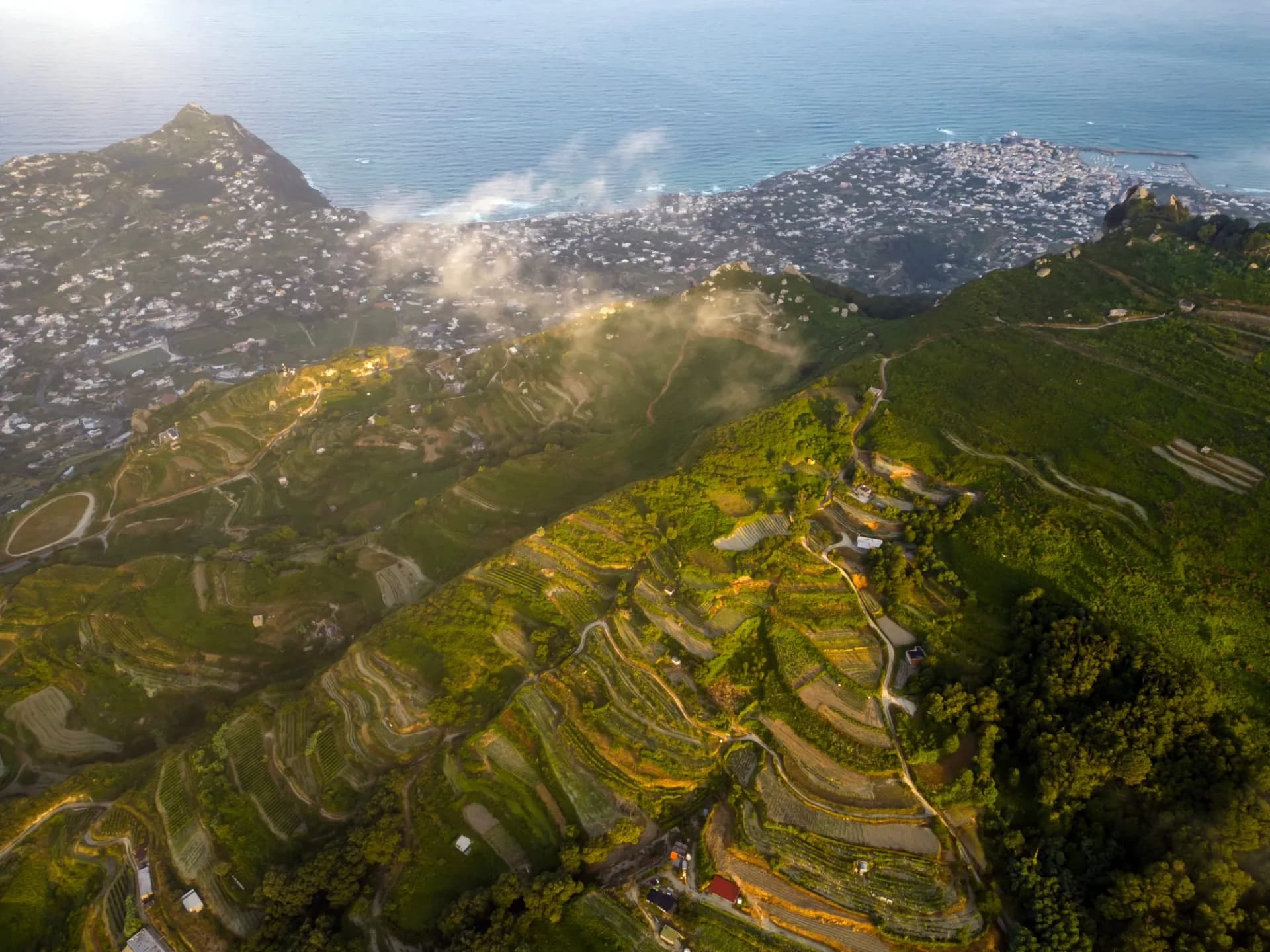 Aerial view at dawn from Mount Epomeo in Ischia. Flight in the clouds with a sea view