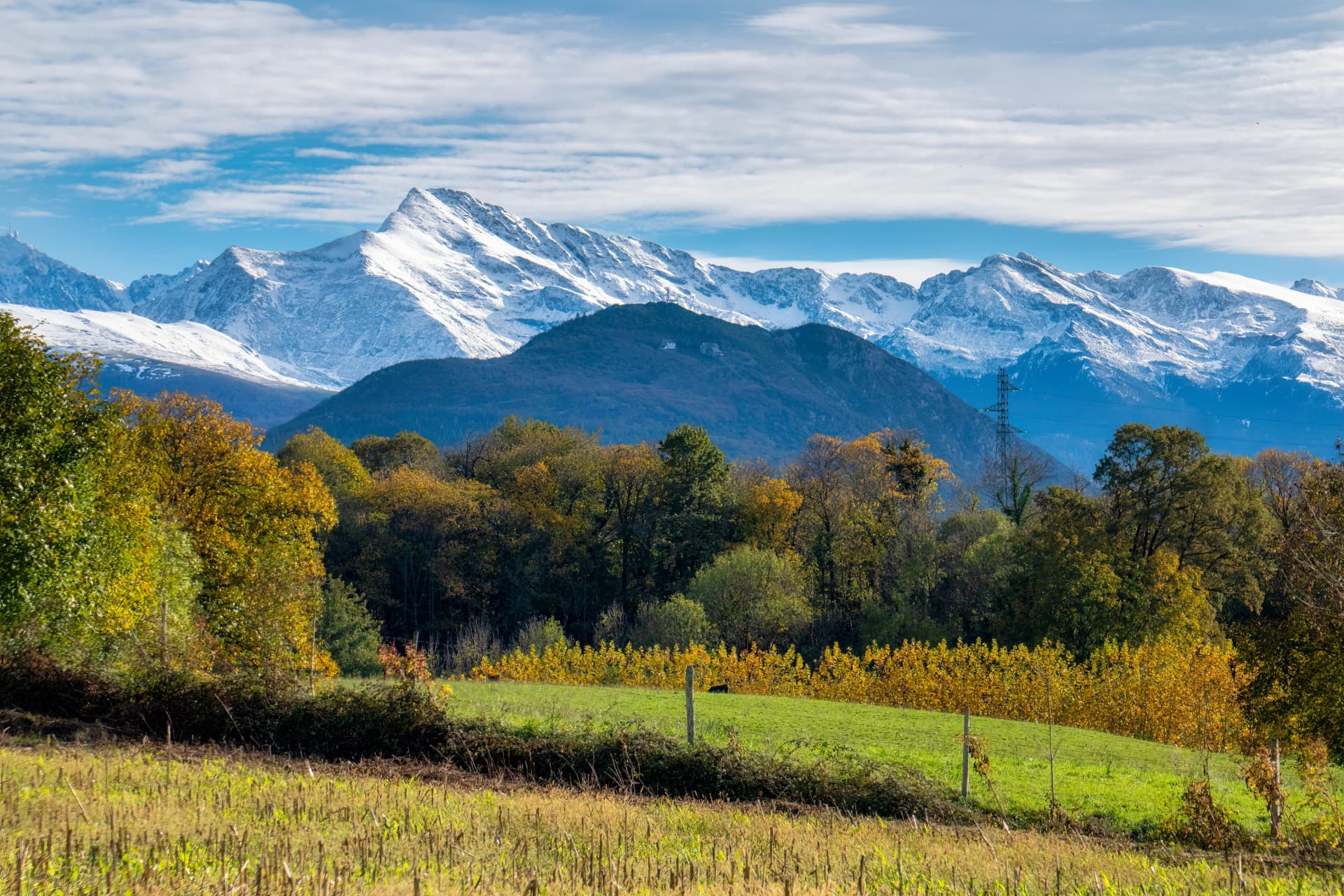 A farm and field at the base of the Pyrenees Mountains