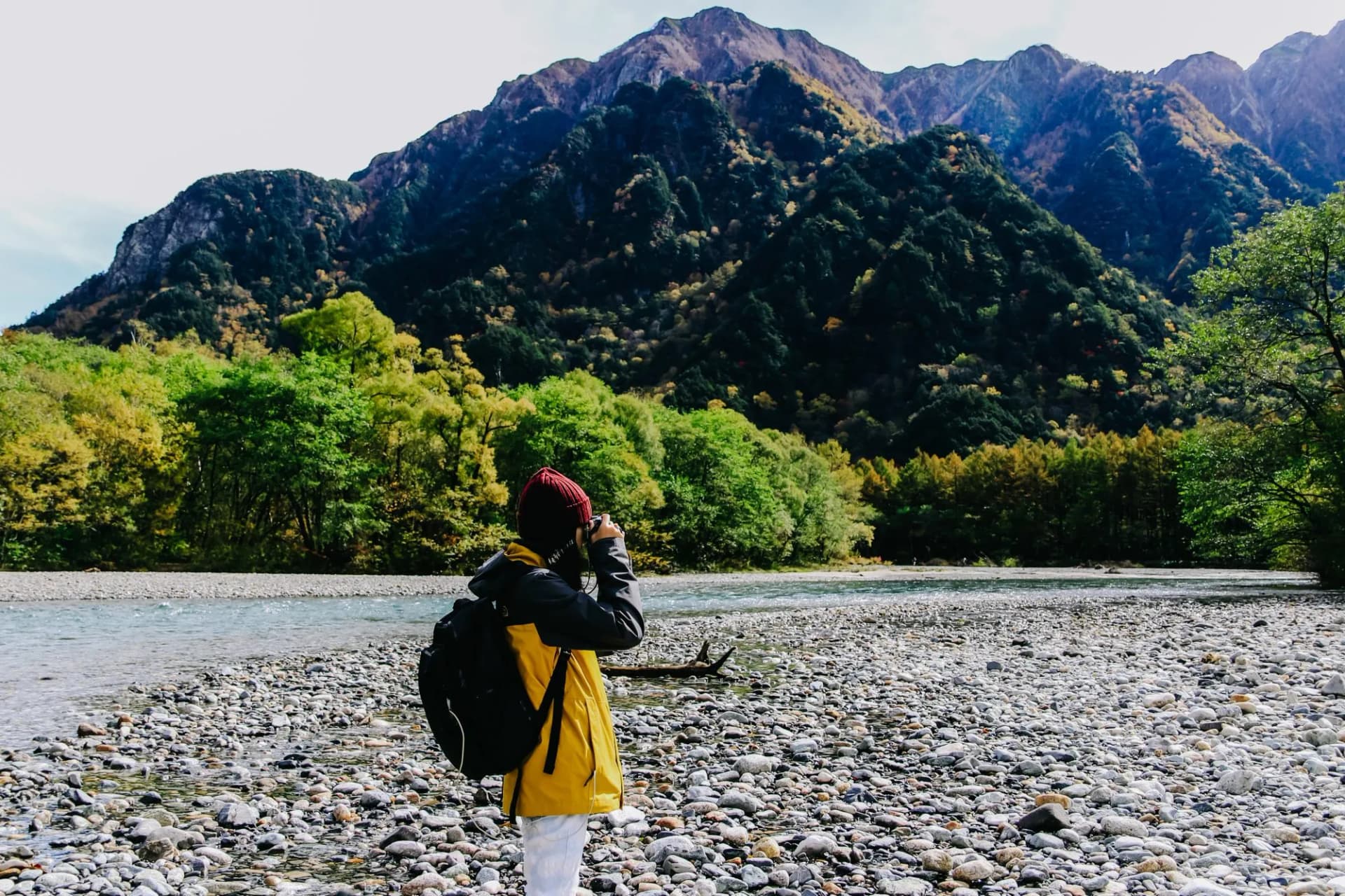 Young woman taking photo with her camera of scenic view at Kamikochi in Nagano prefecture, Japan.