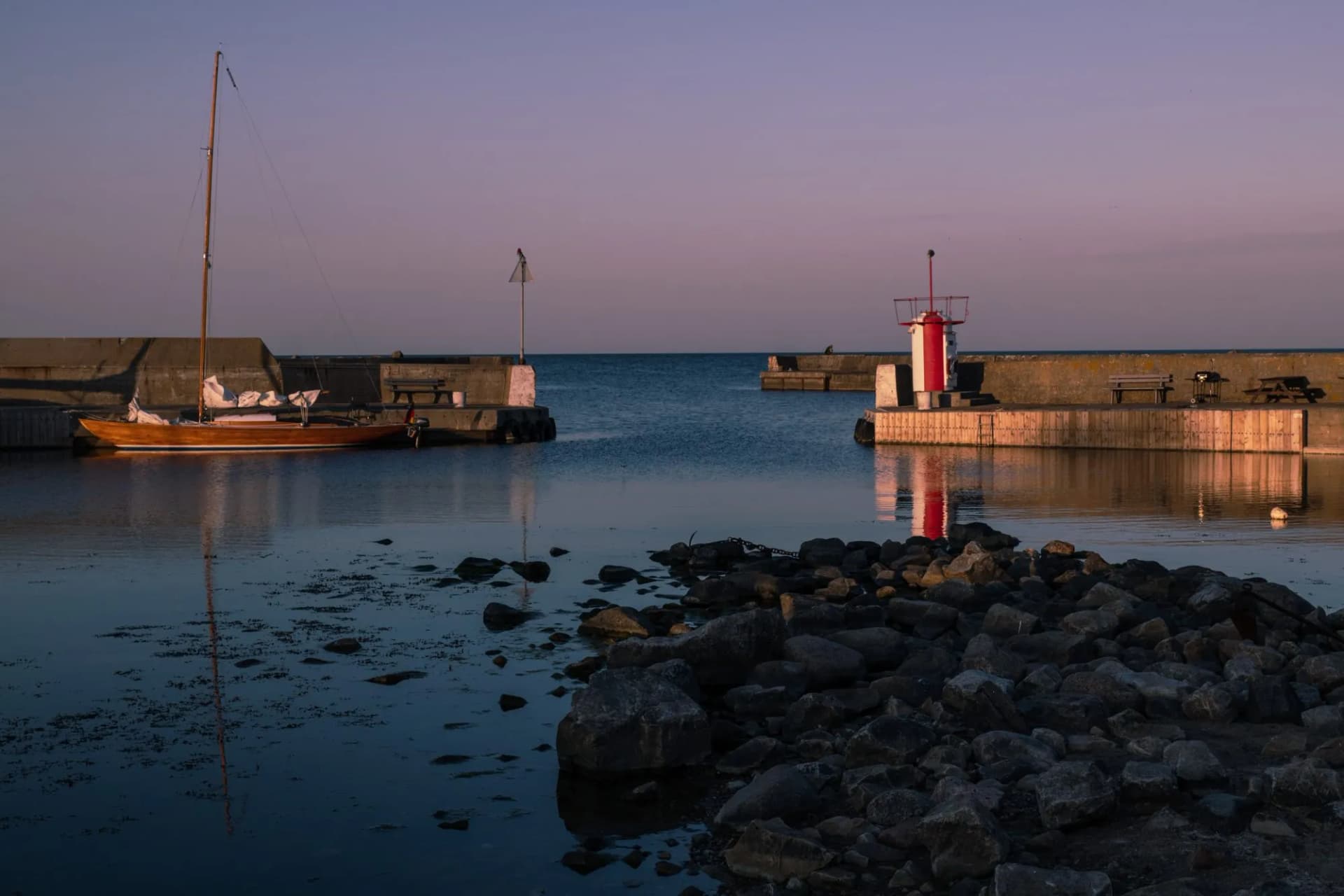 lighthouse in the harbor of brantevik at sunset