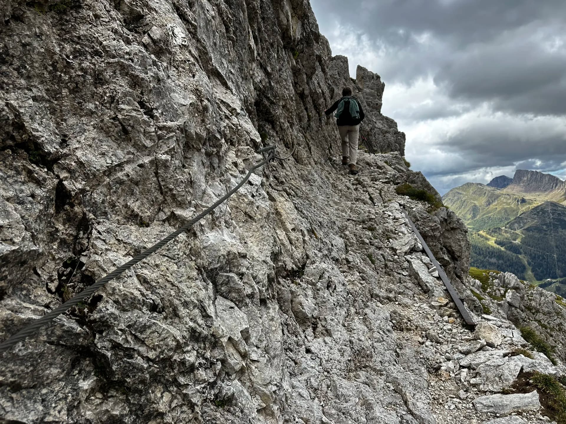 Hiker on a technical via ferrata trail in the Pale di San Martino mountains.