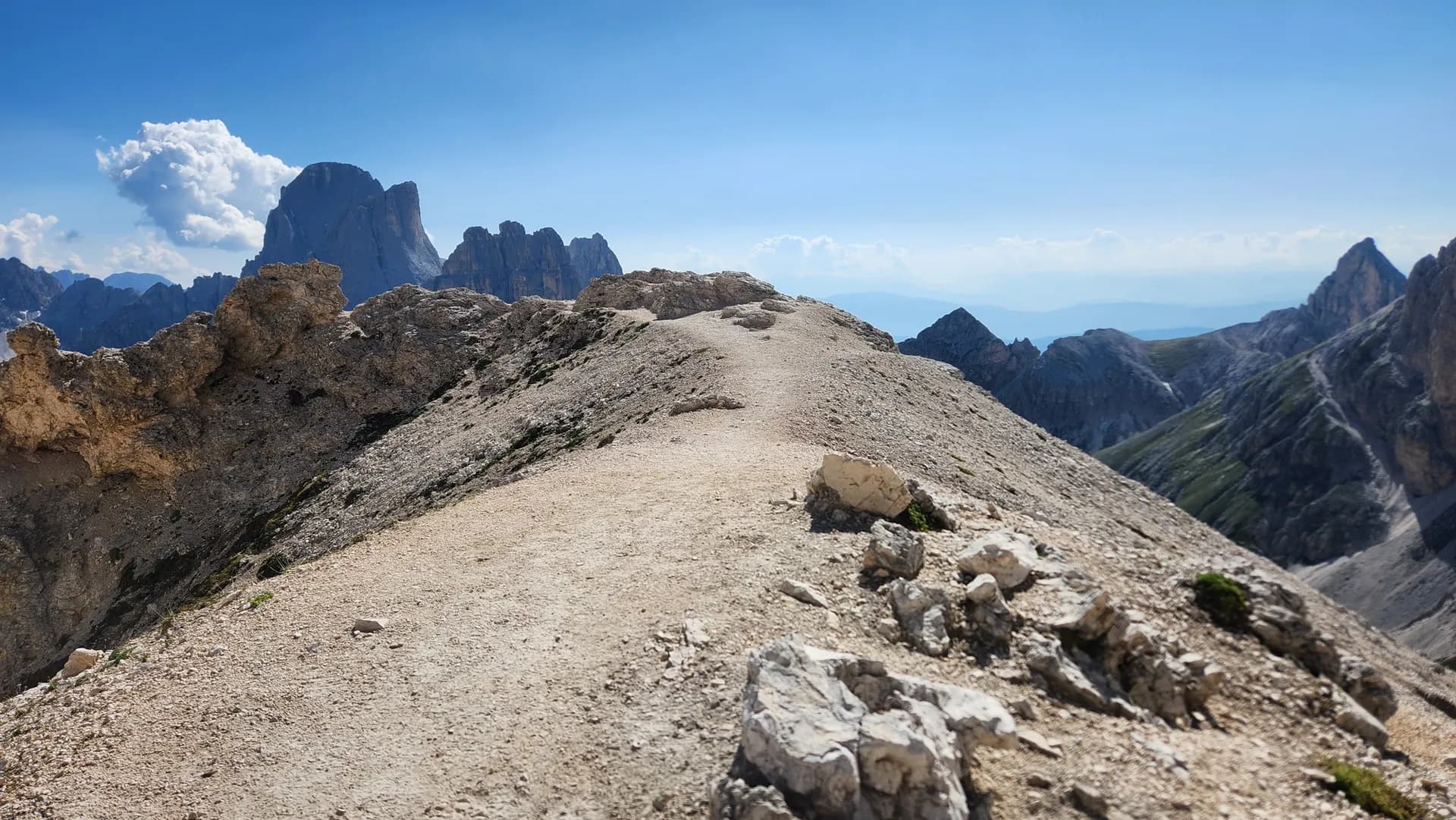 Rocky hiking trail leading toward the Rosengarten mountain group in the Seiser Alm area of the Dolomites.