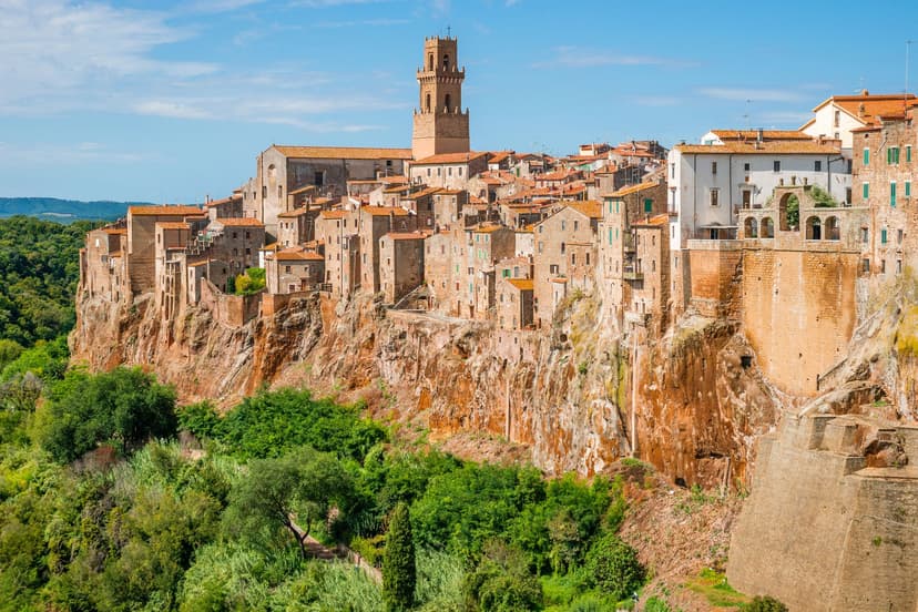 Pitigliano historic town perched on a tuff cliff with stone buildings and a bell tower in Maremma, Italy
