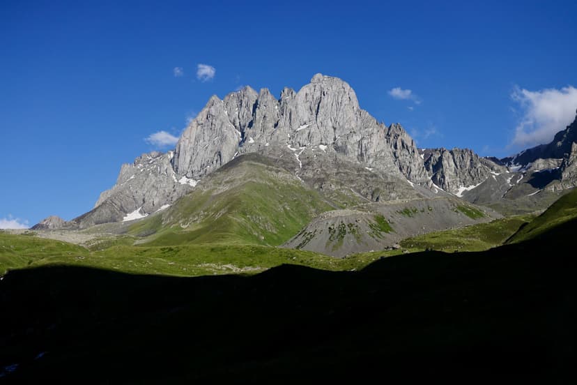 Chaukhi Massif rocky peaks and green slopes near Juta, Georgia under blue sky