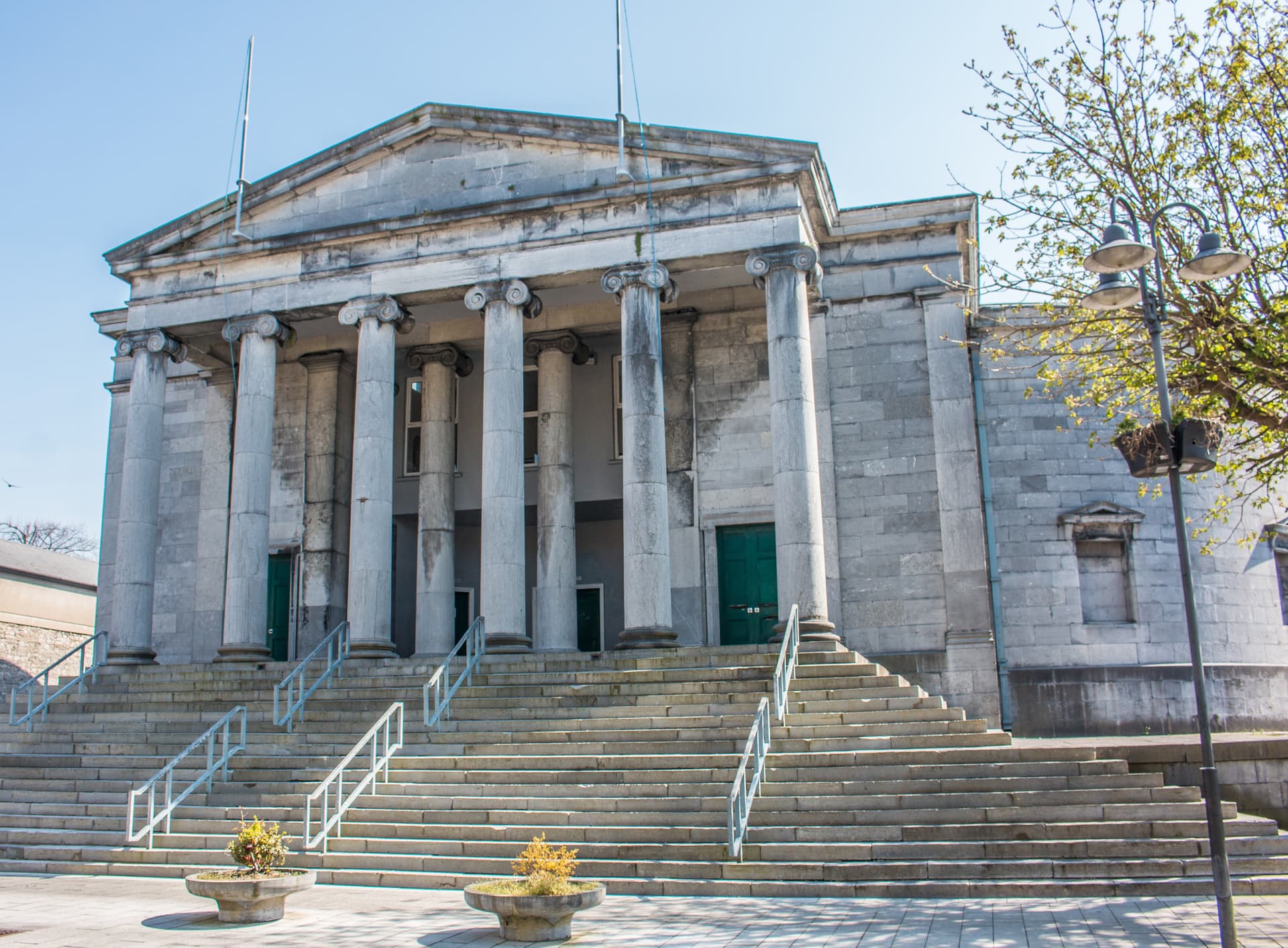 Tralee Courthouse featuring a grand stone facade with Ionic columns and wide exterior steps.