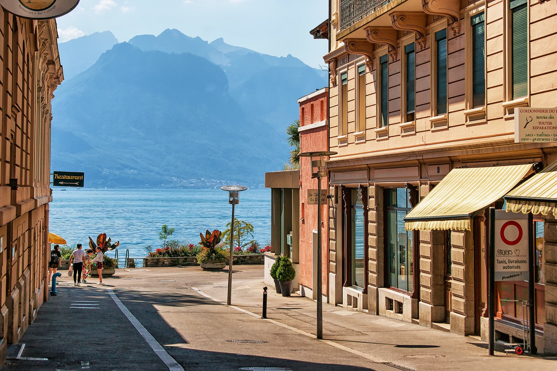 Street scene in Montreux with lake and hazy blue mountains in the background.