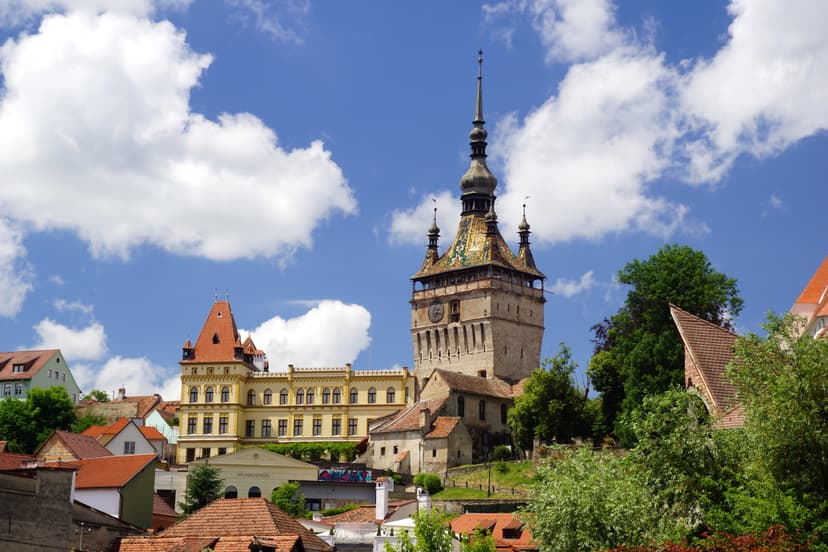 Clock tower with ornate spire and tile roof in historic European town square