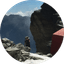Hiker with backpack walking on rocky mountain terrain
