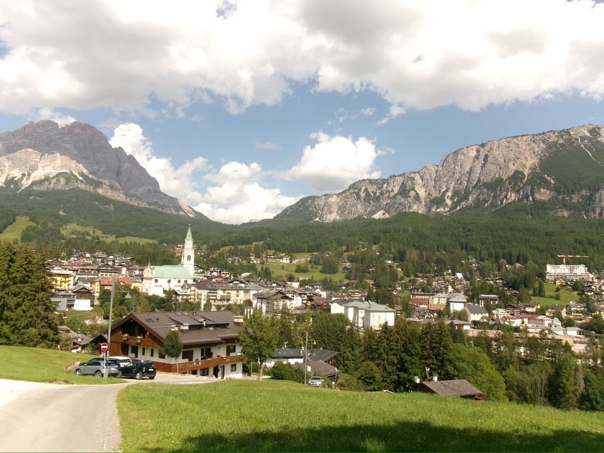 Alpine village nestled in a mountain valley surrounded by rocky peaks and forests