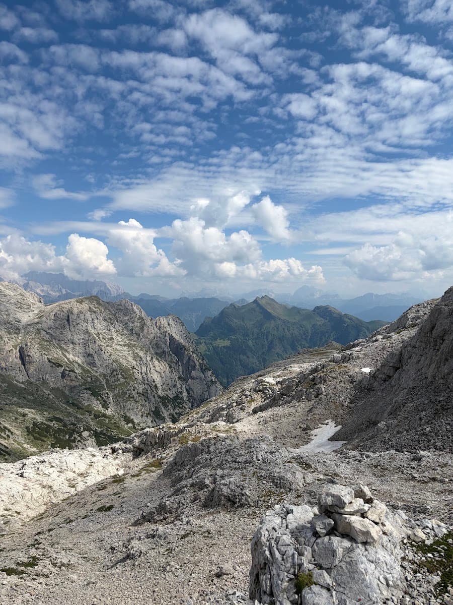 Rocky mountain landscape with alpine peaks and partly cloudy blue sky