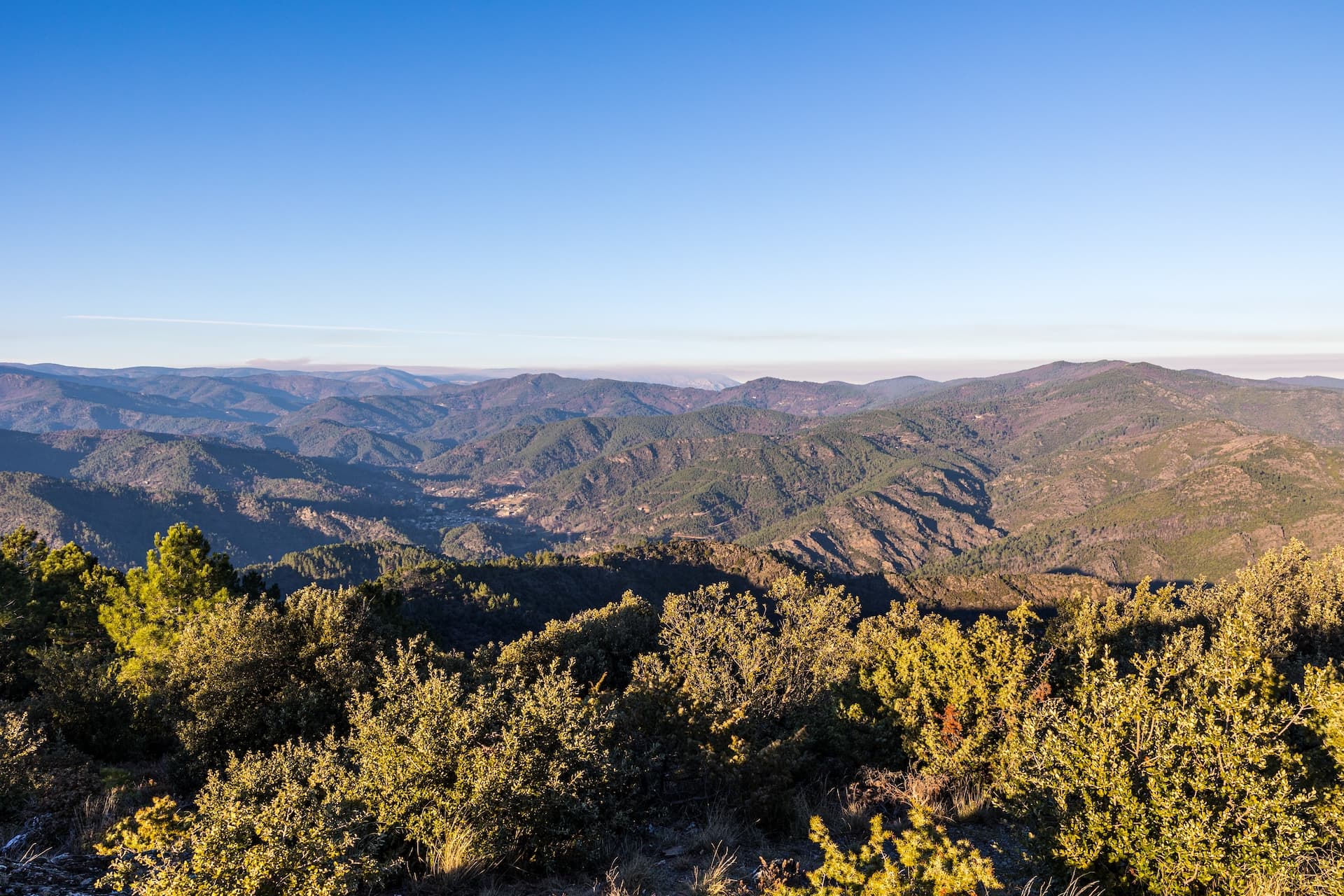 Hiking viewpoint overlooking forested mountains and valley in Saint-Étienne, Vallée Française.