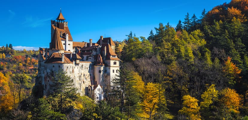 Bran Castle surrounded by autumn foliage and forests in Romania