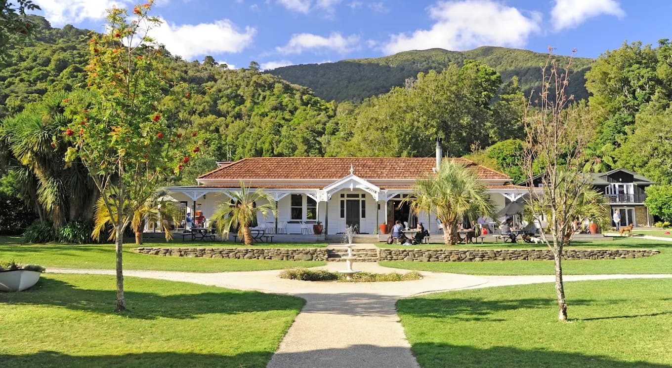 Furneaux Lodge white historic building with red roof in a green valley setting