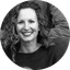 Smiling woman with curly hair in a circular black and white portrait