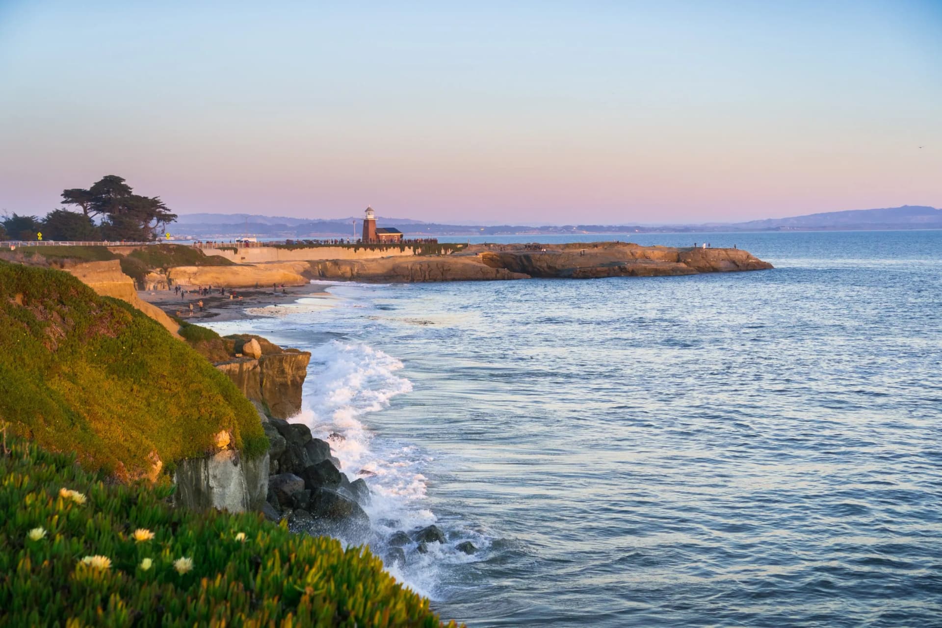 Sunset view of the Pacific Ocean rugged coastline, Santa Cruz, California; Santa Cruz surfing museum in the background