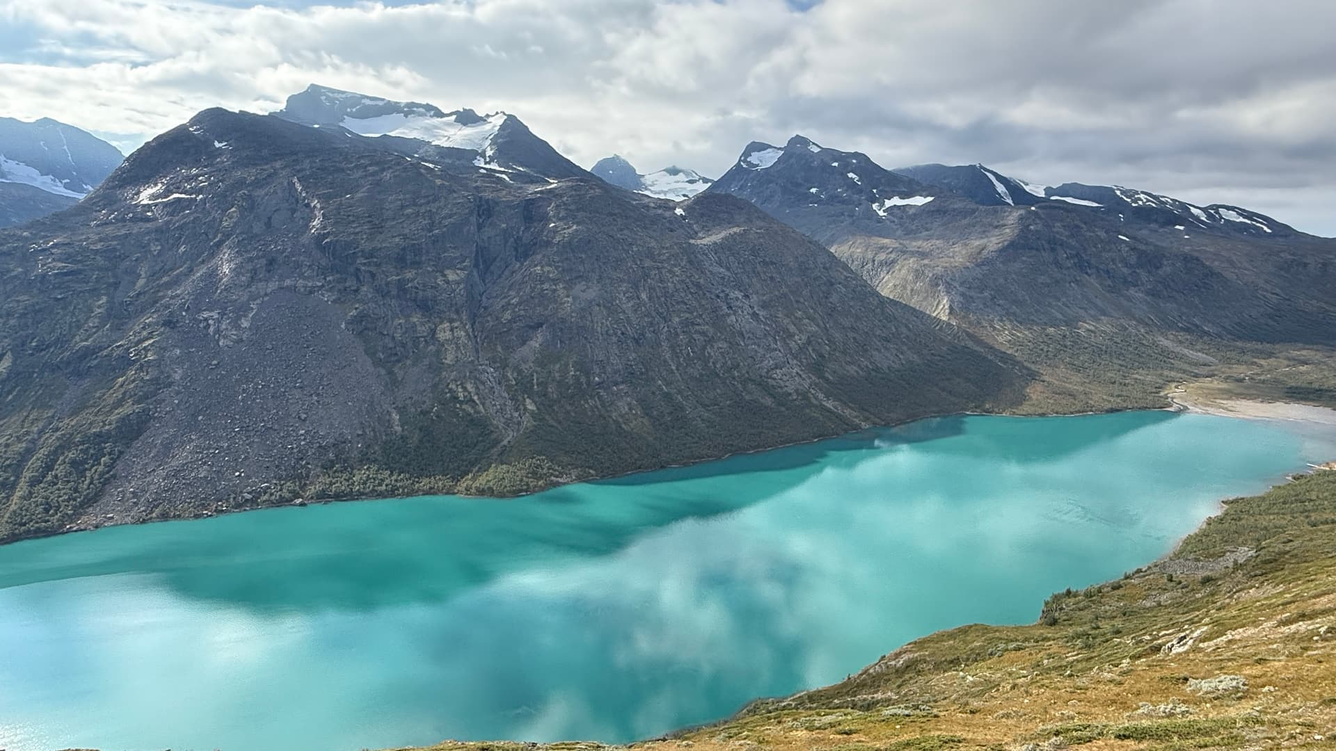 Turquoise Gjende lake beneath glacier-covered mountains