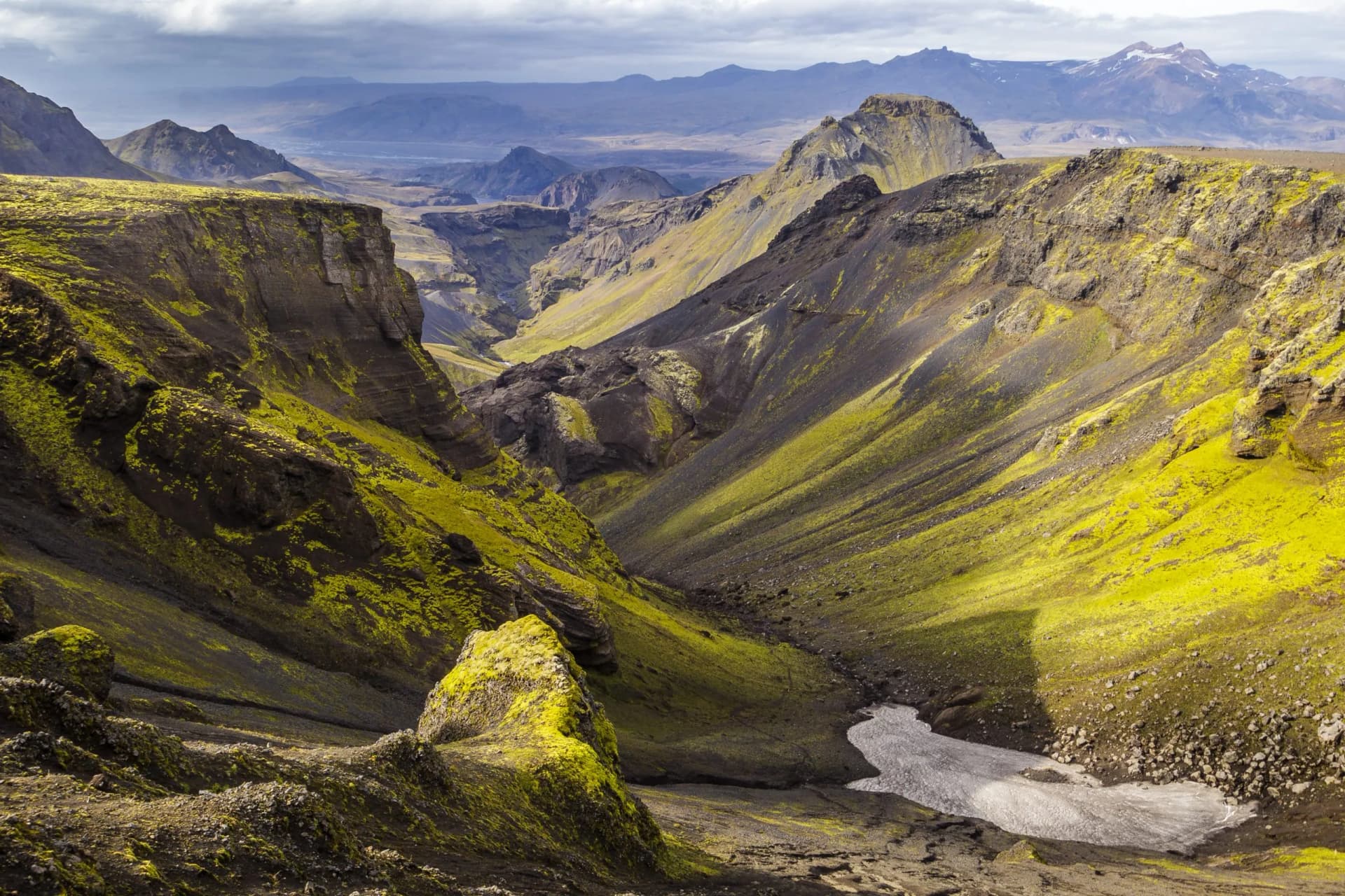 Hiking on Fimmvorduhals in summer: View north through a valley, with moss covered mountainsides.