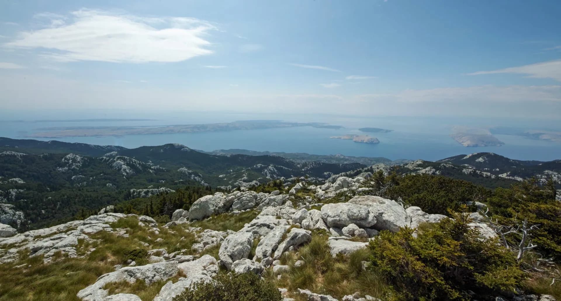 Rocky mountain landscape overlooking the Adriatic Sea and islands under a blue sky