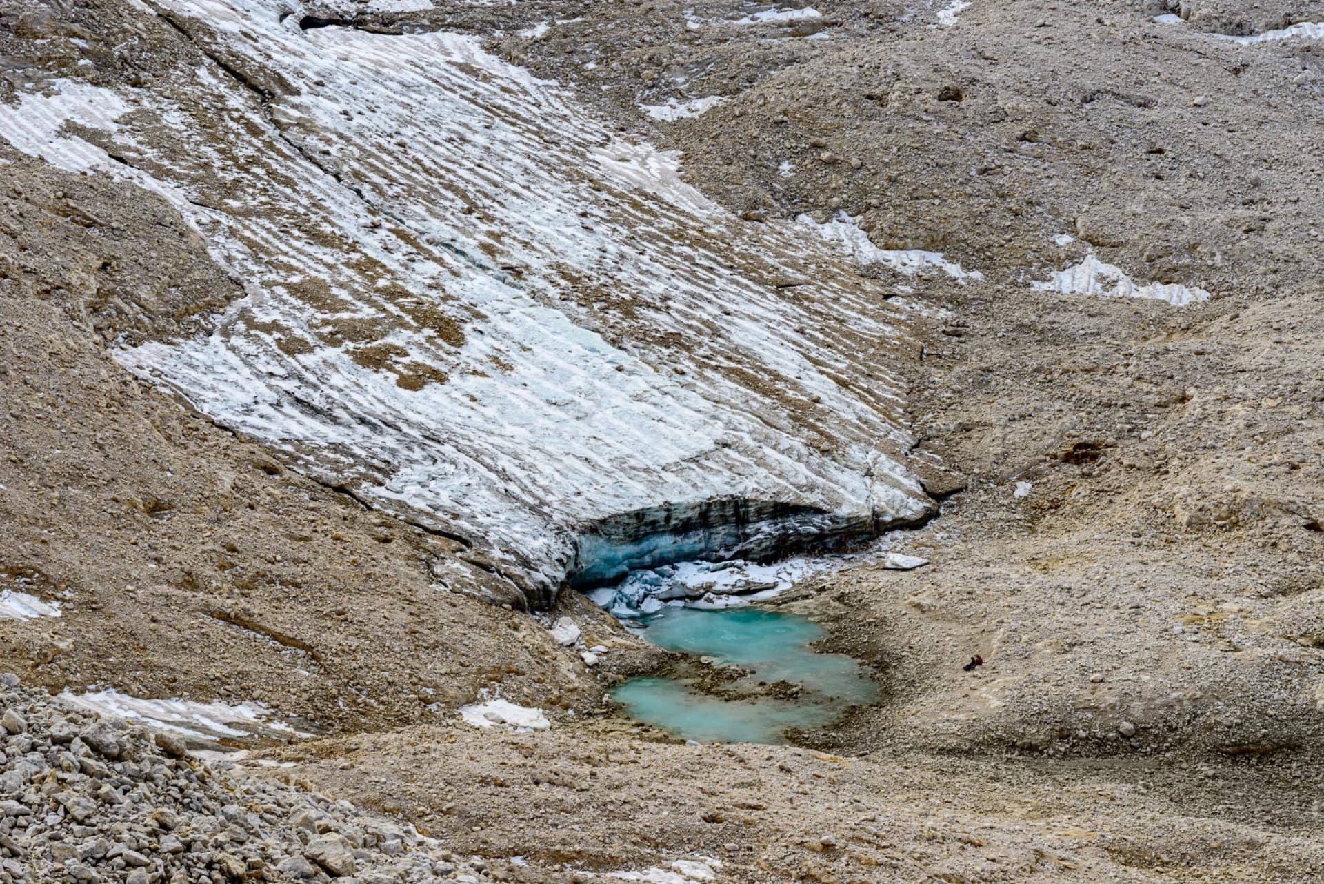 Glacier terminus with meltwater pool, surrounded by rocky moraine, Fradusta Glacier.