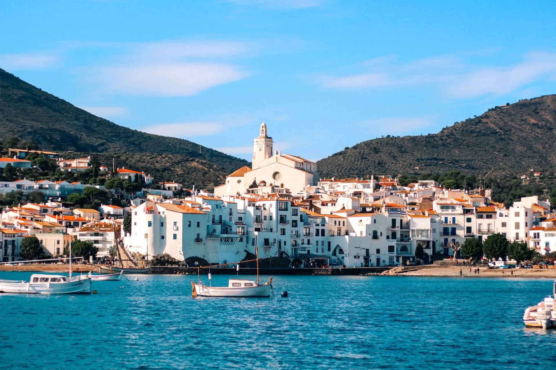 Whitewashed houses of Cadaqués stacked around a calm blue bay