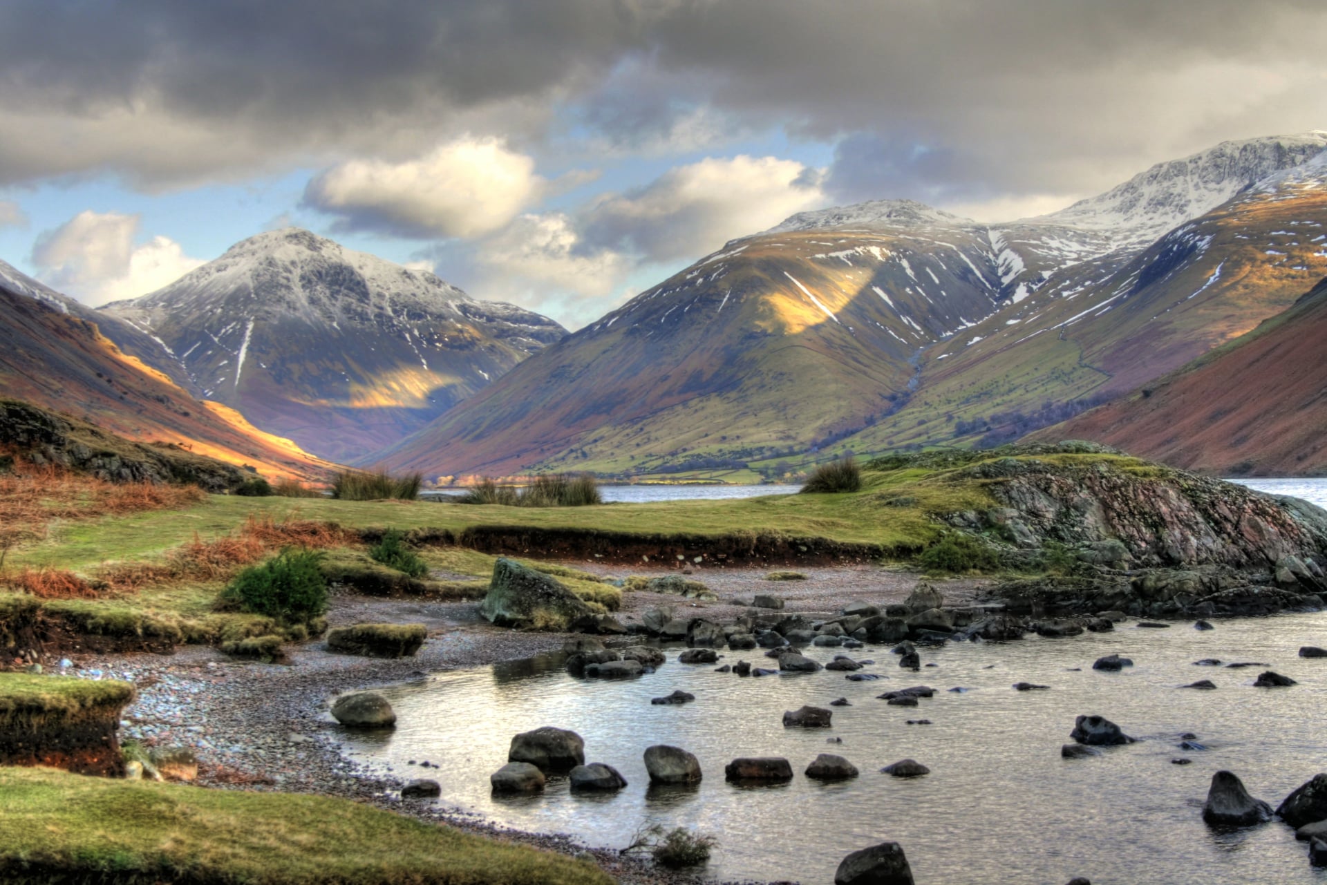 The shingle shore of Wast Water with snow streaked fells closing the valley head